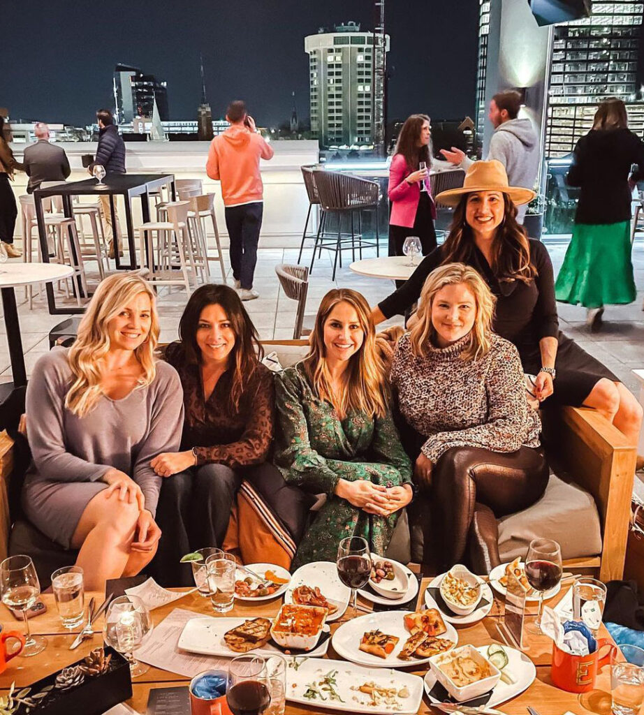 Women enjoying drinks and snacks on the rooftop