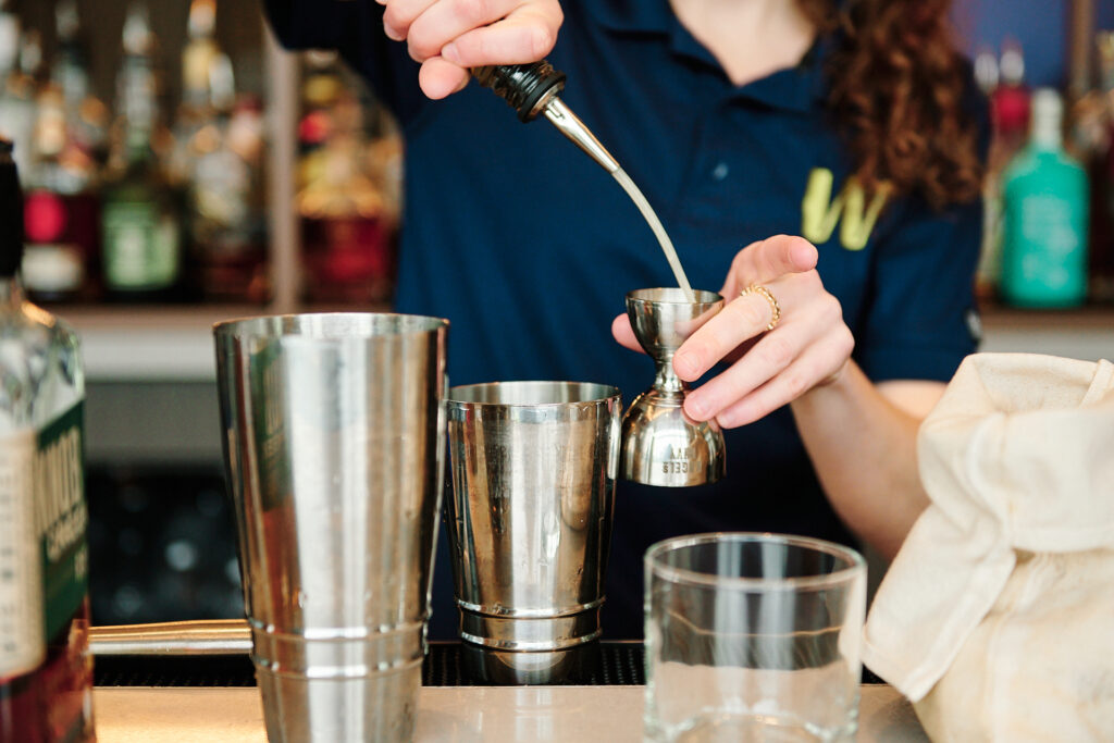 a bartender pouring a cocktail