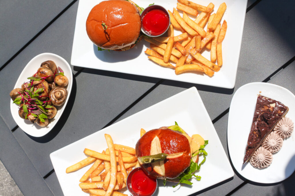 Burger, French fries, pastry served on plates